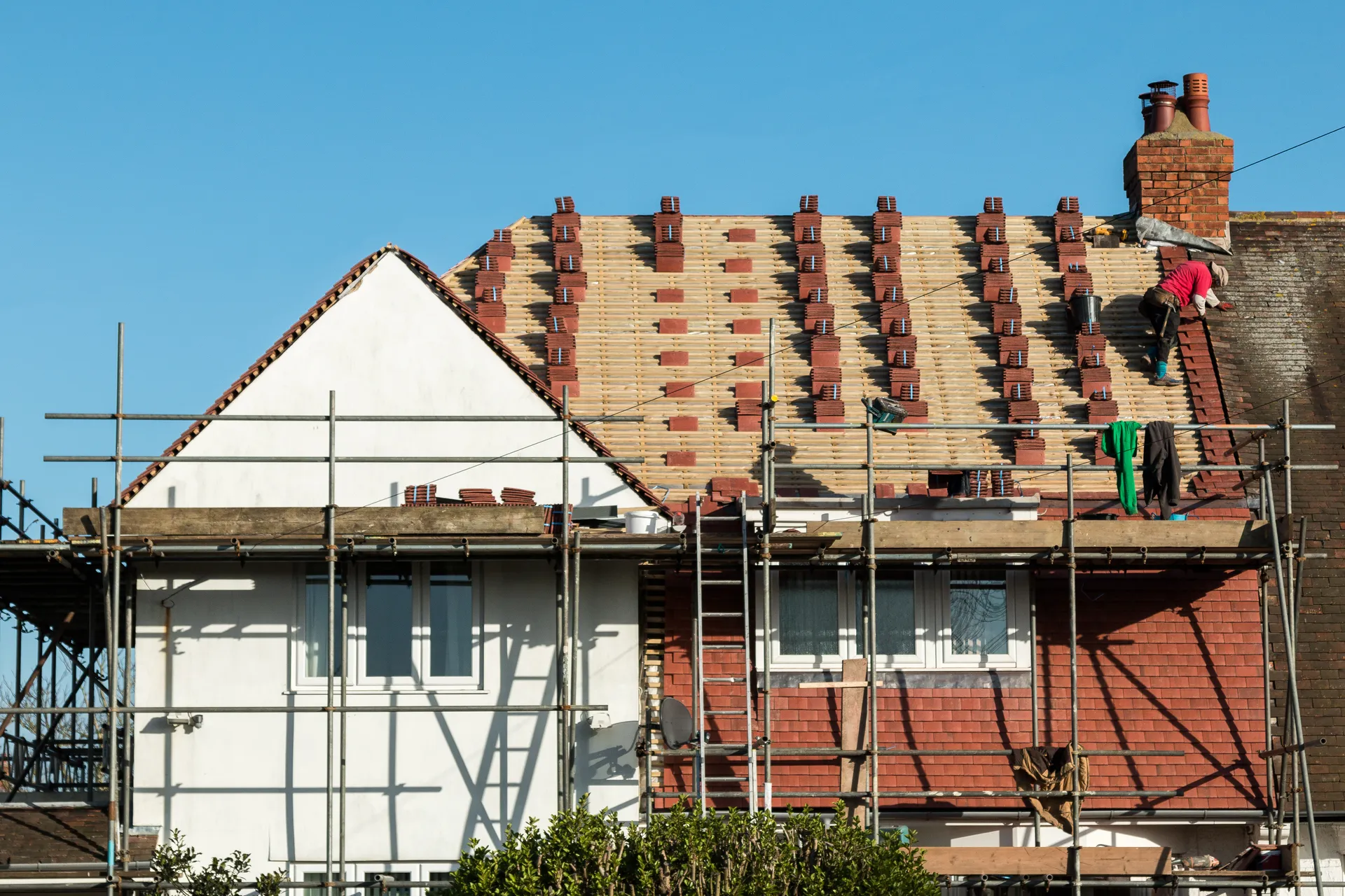 A house re-roof in progress with scaffolding and new battens